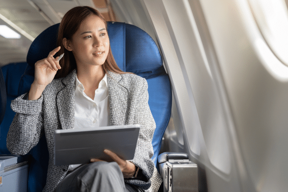 “South African employment law abroad: businesswoman working on laptop during international flight”